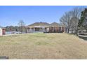 Inviting front exterior featuring a brick facade, well-manicured lawn, and waterfront view at 205 Castlewood Rd, Tyrone, GA 30290