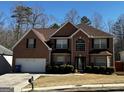 Charming brick two-story home features a manicured front yard, attached garage, and welcoming entrance at 4683 Derby Loop, Fairburn, GA 30213