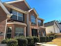 A well-maintained red brick home with large windows, black shutters, and tidy front bushes at 4683 Derby Loop, Fairburn, GA 30213