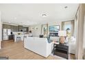 Bright, open-concept living room with modern furnishings, fireplace, and stainless steel appliances at 10465 Trellis Lane (Lot 26), Hampton, GA 30228