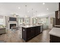 Open-concept kitchen with large island, stainless steel appliances, and view into the living area with fireplace at 10471 Trellis Lane (Lot 25), Hampton, GA 30228