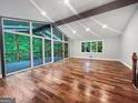 Bright living room with vaulted ceilings, exposed beams, hardwood floors and access to a screened-in porch at 102 Pinegate Rd, Peachtree City, GA 30269