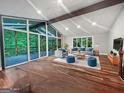 Bright living room with vaulted ceilings, exposed beams, hardwood floors and access to a screened-in porch at 102 Pinegate Rd, Peachtree City, GA 30269