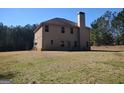 Rear view of home shows brick accents and spacious yard, mature trees around property at 276 Arborview Dr, Mcdonough, GA 30252