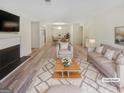 Staged living room featuring neutral tones, fireplace, dining area, and hardwood floors at 2725 St Augustine Trl, Marietta, GA 30067