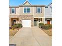 Charming exterior of a two-story townhome with a one-car garage and well manicured front yard at 3232 Tarian Way, Decatur, GA 30034