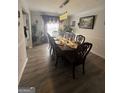 Spacious dining room with hardwood floors, stylish lighting, and seating for eight at 1631 Royal Ives Dr, Lawrenceville, GA 30045