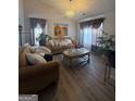 Bright living room featuring hardwood floors, stylish furniture, and elegant decor at 1631 Royal Ives Dr, Lawrenceville, GA 30045