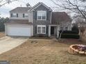Charming two-story home with stone accents, attached garage, and tidy front yard landscaping at 1631 Royal Ives Dr, Lawrenceville, GA 30045
