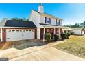 Charming two-story home with a well-maintained front yard, brick accents, and a two-car garage at 261 Whistle Way, Locust Grove, GA 30248