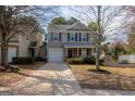 Charming two-story home with gray siding, black shutters, covered porch, and a well-manicured front yard at 5790 Ridge Stone Way, Cumming, GA 30041