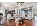 Open-concept living room with hardwood floors, a large sectional sofa, and seamless flow to the dining area at 224 Jester Ct, Mcdonough, GA 30252