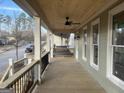 Inviting porch with ceiling fan, wooden floor, and black metal railing at 5106 N Pratt St, Covington, GA 30014