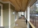 Inviting porch with ceiling fan, wooden floor, and black metal railing at 5106 N Pratt St, Covington, GA 30014