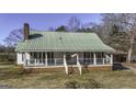 Classic house with a brick chimney and inviting front porch with white railings at 128 Turner Ln, Bowdon, GA 30108