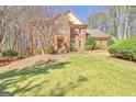 Traditional brick home boasts a well-manicured lawn and mature landscaping at 233 Spear Rd, Fayetteville, GA 30215