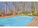 A refreshing pool with a waterfall feature, hot tub and wooden swing set in a serene backyard setting at 233 Spear Rd, Fayetteville, GA 30215