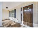 View of front door and covered porch with wooden door and decorative sidelight at 603 Honey Creek Rd, Mcdonough, GA 30252