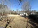 Expansive backyard with bare trees and underbrush, offering potential for customization and landscaping at 650 Harris Dr, Locust Grove, GA 30248