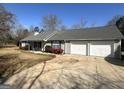 Exterior view of a well-maintained home and driveway with a spacious three-car garage at 650 Harris Dr, Locust Grove, GA 30248