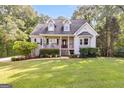 Attractive home featuring dormer windows, a cozy front porch, manicured landscaping, and a well-maintained lawn at 47 Long Island Dr, Whitesburg, GA 30185