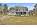 Beautiful home featuring a cozy front porch, a two-car garage, and a well-maintained lawn at 100 Spincast Ct, Peachtree City, GA 30269