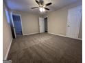 Carpeted bedroom featuring a ceiling fan, neutral walls and two doors leading to the other parts of the home at 3756 Bright Star Rd, Douglasville, GA 30135