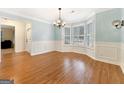 Elegant dining room featuring wood floors, decorative molding, and bright bay windows with shutters at 642 Grecken Grn, Peachtree City, GA 30269