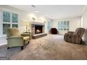 Inviting living room with a brick fireplace and large windows providing ample natural light at 642 Grecken Grn, Peachtree City, GA 30269