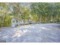 Home's front exterior featuring a wooden wheelchair ramp surrounded by mature trees at 4226 Highway 155 N, Stockbridge, GA 30281