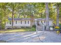 Charming single-story home with a stone chimney, wooden wheelchair ramp, and mature trees at 4226 Highway 155 N, Stockbridge, GA 30281