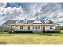 Charming farmhouse with an expansive front porch, pristine white siding, and a lush green lawn at 271 Trestle Rd, Locust Grove, GA 30248