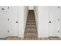 Carpeted staircase between two doors, leading to the upper level of the home, providing a clean and simple design at 2391 Wellborn Hills Ct, Lithonia, GA 30058