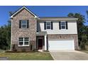 Charming two-story home with brick and light gray siding, a two-car garage, and a well-manicured lawn at 106 Silverton Dr, Dacula, GA 30019