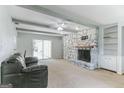 Spacious living room features a stone fireplace, beamed ceilings, and sliding glass doors at 1408 Fairfield Sw Dr, Lilburn, GA 30047