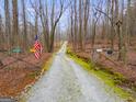 A long gravel driveway leads to a secluded property, ensuring privacy and tranquility at 630 Stoney Point Rd, Bowdon, GA 30108