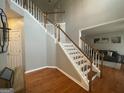 Spacious entryway featuring hardwood floors and staircase with white railing at 4043 Windgrove Xing, Suwanee, GA 30024