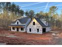 Exterior view of a home under construction with exposed wood and wrap, set in a wooded area at 4585 Parkwood Dr, Social Circle, GA 30025