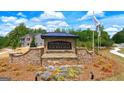 Welcoming entrance to The Enclave at Flat Rock Hills with stone signage and landscaped flower beds at 5429 Flat Rock Point # 1, Stonecrest, GA 30038