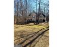 A wide view of a two-story home with black shutters, set back on a spacious lot with mature trees at 245 Ashley Forest Dr, Fayetteville, GA 30214