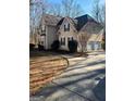 A two-story home with a winding driveway and attached two-car garage, surrounded by trees and shrubbery at 245 Ashley Forest Dr, Fayetteville, GA 30214