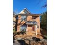 Charming brick townhome exterior featuring a covered porch and large windows for natural light at 3874 Austin Park Ne Ln, Decatur, GA 30032