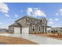 Spacious home featuring a three-car garage, gray siding and a long driveway at 275 Arwen Dr # 68, Mcdonough, GA 30252
