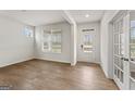 Bright living room featuring wood floors, white walls, windows, and glass-paneled doors at 275 Arwen Dr # 68, Mcdonough, GA 30252