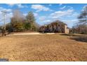 View of the brick home from the large front yard. Circular driveway with fountain and wrought iron gate at 1408 Hemphill Rd, Stockbridge, GA 30281