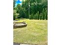 Landscaped front yard featuring a fountain and row of evergreen trees at 2555 Rockbridge Nw Rd, Conyers, GA 30012