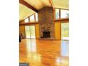Spacious living room with a stone fireplace, vaulted ceilings, and wood floors at 2555 Rockbridge Nw Rd, Conyers, GA 30012