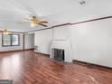 Spacious living room featuring hardwood floors, a fireplace, and a ceiling fan that provides great air circulation at 1713 Bramlett Shoals Rd, Lawrenceville, GA 30045