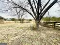 A tree providing shade along a rustic wooden fence at 3210 Rogers Rd, Mcdonough, GA 30252
