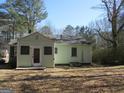 Back of the house showcasing the door, an enclosed porch, and mature trees surrounding the property at 1989 Grant Sw Rd, Atlanta, GA 30331